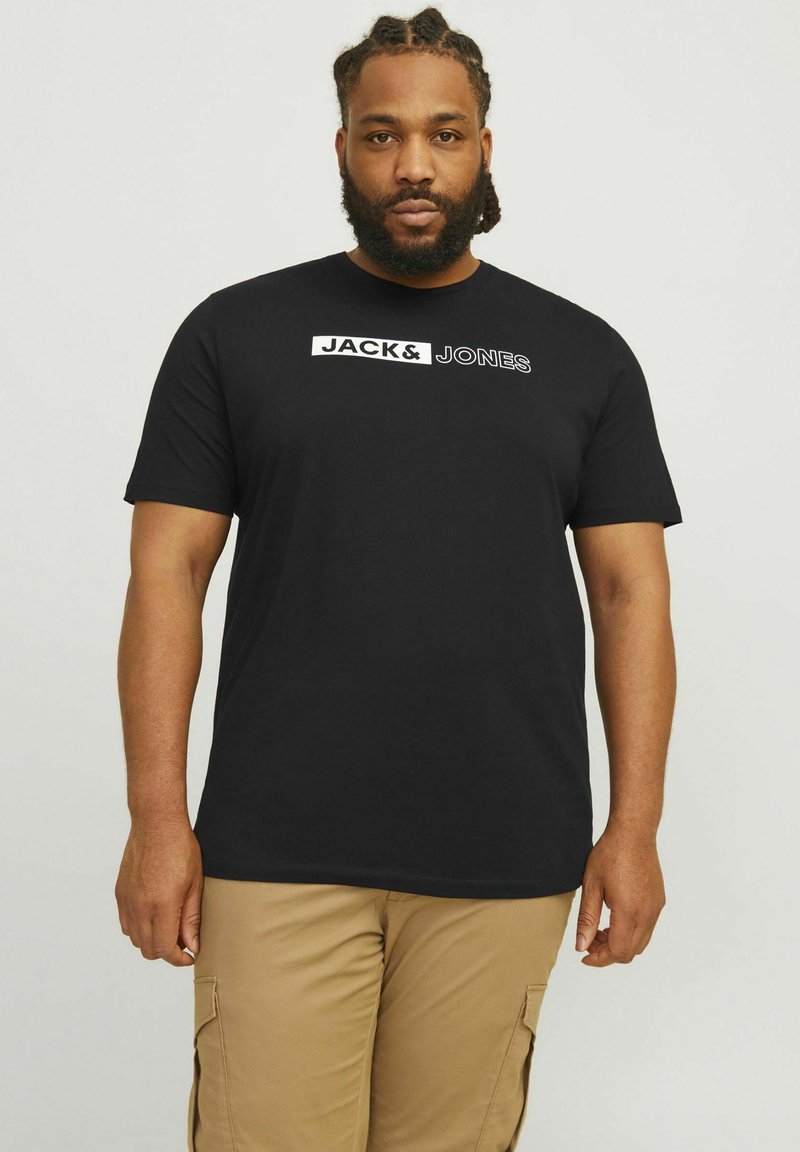 Crna pamučna majica s kratkim rukavima, s bijelim ispisom "JACK&JONES" preko prsa, okrugli izrez i opušteni kroj.