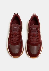 Baskets bordeaux en suède et cuir, avec une languette en mesh, des détails texturés, et une semelle blanche tachetée avec une semelle extérieure en caoutchouc marron.