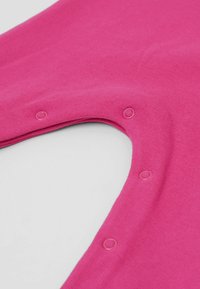 Fuchsiová bavlněná oděv s kulatým výstřihem a patkovými knoflíky po jedné straně, s hladkým povrchem a rovnoměrným šitím.