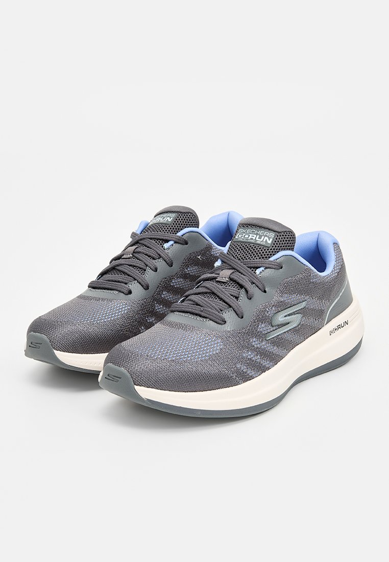 Zapatillas de correr ligeras en malla gris oscuro con acentos en azul. Suela acolchada, diseño con cordones y un logo elevado en el lateral.