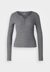 Graues, geripptes Langarmshirt mit einem Henley-Ausschnitt und vier Knöpfen. Es hat eine figurnahe Passform und eine weiche Textur, ideal für legere Anlässe.