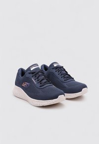 Zapatillas deportivas navy de malla transpirable, con una suela texturizada de diseño moteado y un logotipo en contraste en el lateral.