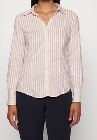 Camicia a maniche lunghe con bottoni, a righe verticali rosa chiaro e bianche, in tessuto di cotone, colletto appuntito, orlo curvato e polsini con bottoni.