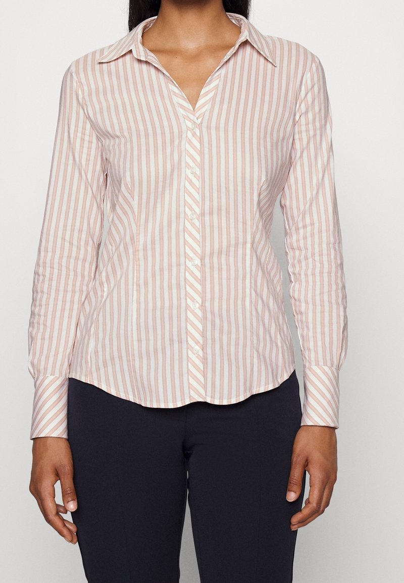 Camicia a maniche lunghe con bottoni, a righe verticali rosa chiaro e bianche, in tessuto di cotone, colletto appuntito, orlo curvato e polsini con bottoni.