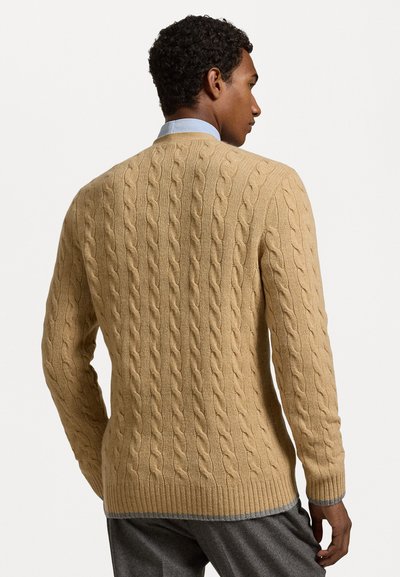 Bežs adīts džemperis ar ribotām piedurknēm un apakšmalu. Izstrādāts ar teksturētu rakstu, tam ir apaļa kakla izgriezums un brīvs piegriezums.