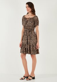 Leopard print dress with a cinched waist, short puff sleeves, and a layered ruffled hem. Made of lightweight fabric; features a tie neckline.