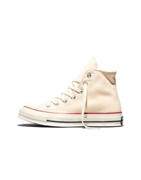 Baskets montantes en toile écrue avec lacets blancs, œillets métalliques et semelle en caoutchouc ornée de bandes rouges et noires.