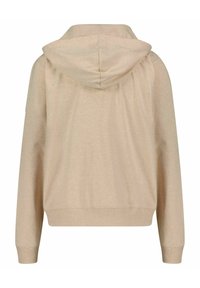 Beige huvtröja i mjukt tyg, med en avslappnad passform, långa ärmar och en rundad nederkant. Inga anmärkningsvärda mönster eller detaljer.