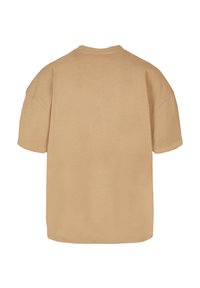 Beige oversized t-shirt med rund halsudskæring, korte ærmer og en glat bomuldsstruktur. Minimalistisk design, ingen synlige logoer eller udsmykninger.