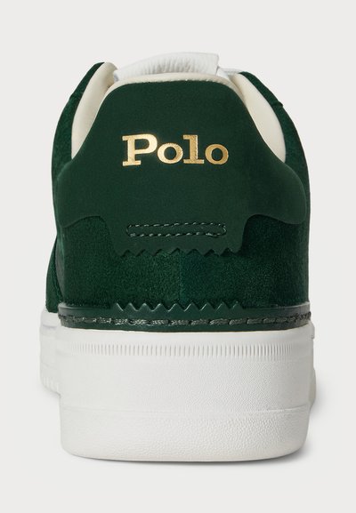Zaļie samta sporta apavi ar baltu gumijas zoli, ar zelta "Polo" logotipu uz papēža un ķīļveida diegu šuvēm ap augšdaļu.