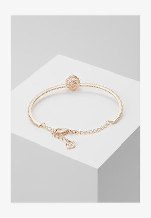 Bracelet en or rose avec un bracelet texturé, un fermoir décoratif avec un design de fleur et un petit charme de cygne avec des accents scintillants.