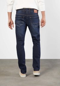 Mörkblå denimjeans med rak skärning, med två bakfickor och en läderlogotyp på midjebandet.