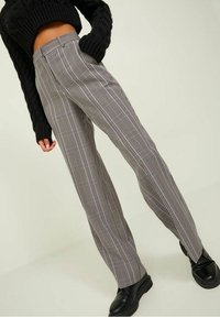 Dopasowane, czarno-białe spodni z wysokim stanem, prostą nogawką, gładką teksturą i delikatnym rozcięciem na dole.