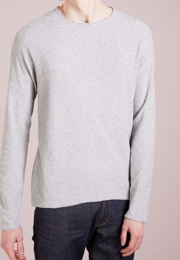 Grauer Langarmpullover aus strukturiertem Stoff mit rundem Halsausschnitt, kombiniert mit dunkelblauer Jeans, die über sichtbare Nahtdetails verfügt.