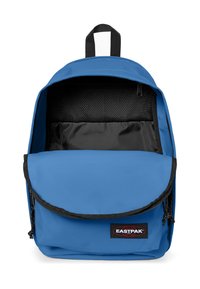 Mochila Eastpak azul que presenta un gran compartimento principal con un bolsillo de malla negra, solapa frontal y parche con el logo. Textura de tejido suave.