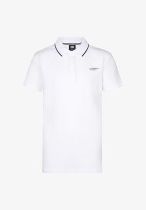 Biała koszulka polo z granatowym kołnierzykiem, jasnoniebieskie szorty dżinsowe, białe trampki i skarpetki w czarne paski. Uśmiechnięte dziecko stoi.