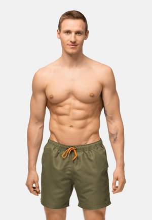 Pantaloni da bagno verdi con vita elasticizzata e lacci arancioni, caratterizzati da una consistenza liscia e un logo sull'orlo.