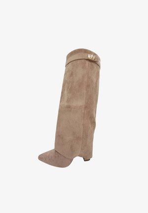 Botte en suède beige montée jusqu'au genou avec un bout effilé et un talon block modeste. Présente un accent doré près du haut. Texture douce sur l'ensemble.