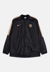 Chaqueta negra de Nike con detalles en dorado, que presenta un cuello alto, cierre de cremallera, bolsillos laterales y el logo del Chelsea FC en el pecho.