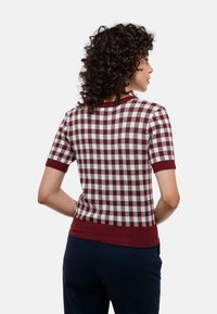 Haut à manches courtes à carreaux en bordeaux et blanc, avec un col et un ourlet côtelés, présentant un motif tricoté texturé au dos.