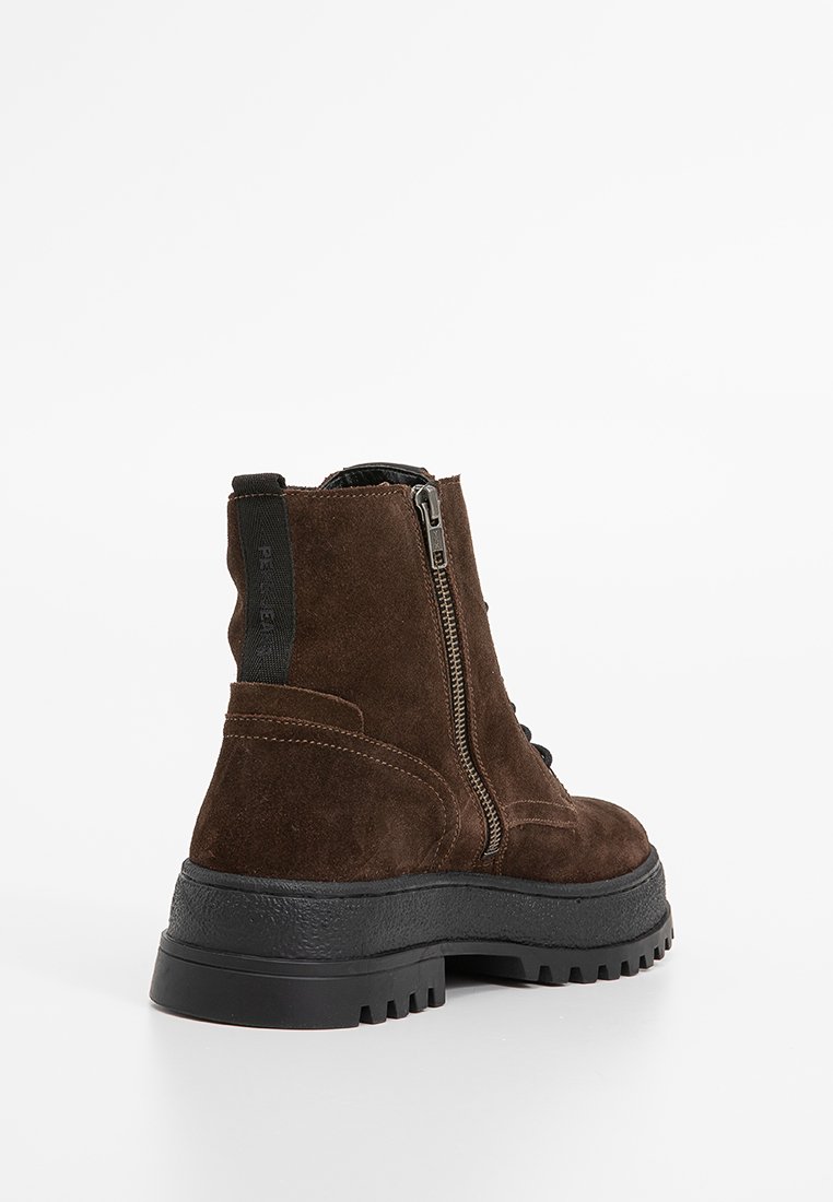 Botas de tobillo de ante marrón con cremallera lateral, suela de goma y detalles texturizados. Presentan un tacón robusto y grueso con costuras en contraste.