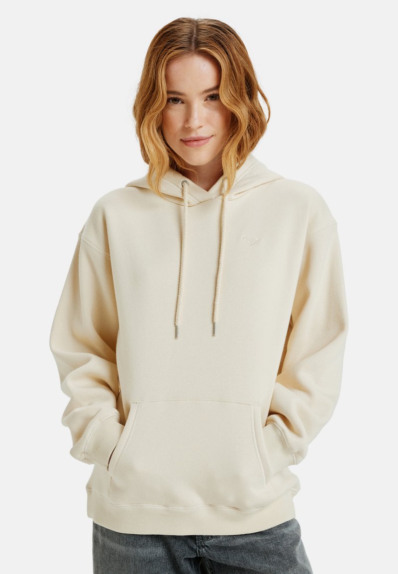 Beige hoodie met trekkoorden, buidelzak en subtiele logo. Gemaakt van zacht materiaal met een ontspannen pasvorm en ribgebreide boorden.