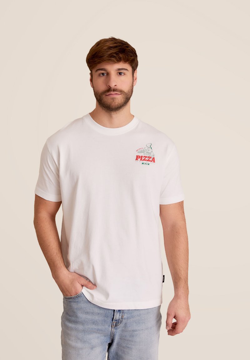 T-shirt en coton blanc avec un graphique coloré sur la poitrine gauche représentant un chef pizzaiolo et le mot "PIZZA". Coupe décontractée avec des manches courtes.