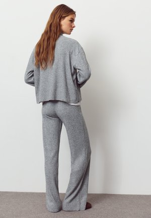 Maglione grigio in maglia con vestibilità comoda e texture a coste, abbinato a pantaloni grigi in maglia aderenti coordinati.