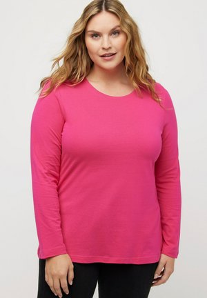 T-shirt a maniche lunghe, con scollo rotondo, di un vivace colore rosa, realizzato in morbido tessuto, con una texture liscia e una vestibilità comoda. Abbinato a pantaloni neri.