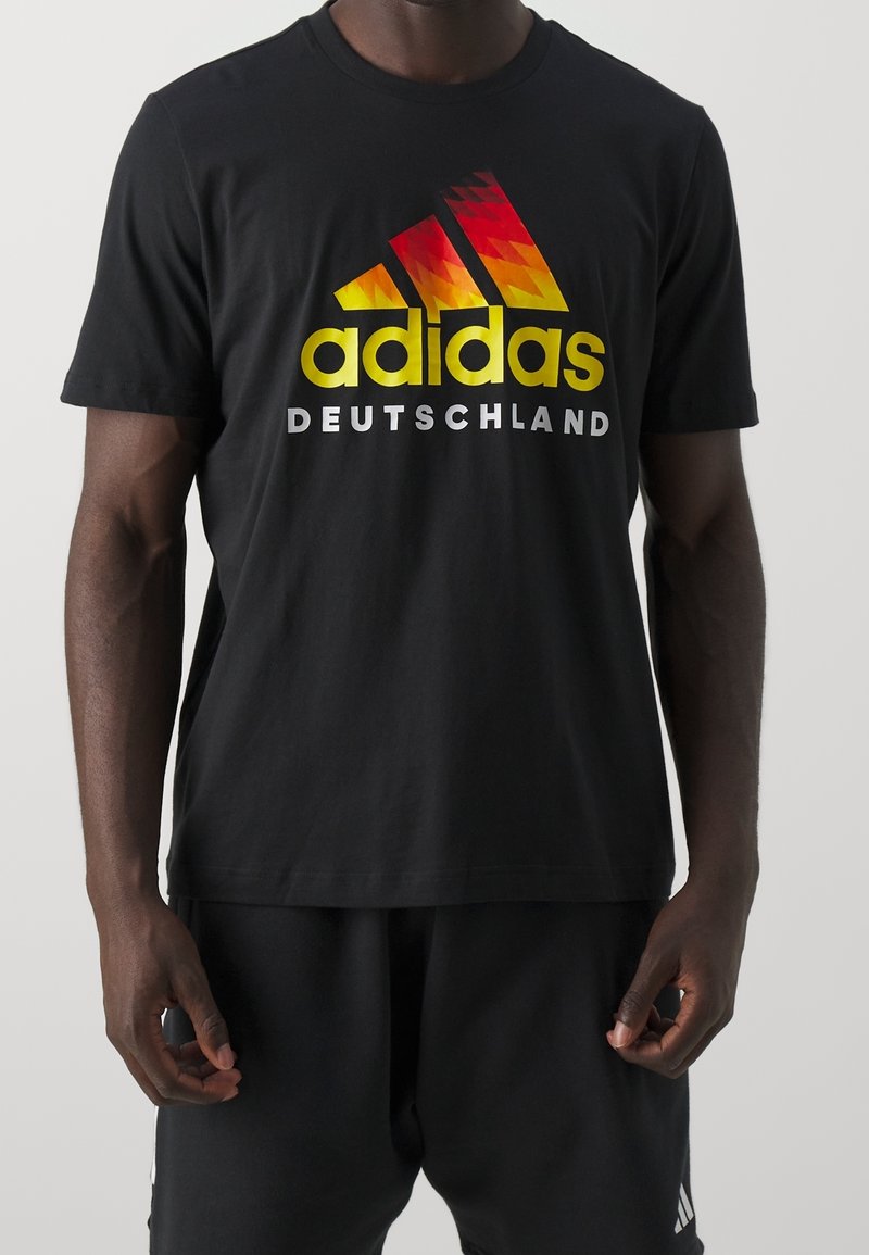 Czarny bawełniany T-shirt z gradientowym logo Adidasa w kolorach żółtym, czerwonym i pomarańczowym oraz napisem "DEUTSCHLAND" poniżej, krótki rękaw, standardowy krój.