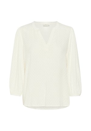 Balta garām piedurknēm blūze ar V-veida kakla izgriezumu, teksturētām punktiņām un saplacinātām piedurknēm. Izgatavota no viegla auduma un tai ir taisna apakšmala.