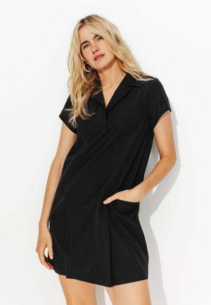 Robe noire avec col, manches courtes et poches ; tissu lisse, design ajusté, longueur genou avec des détails de coutures subtils.