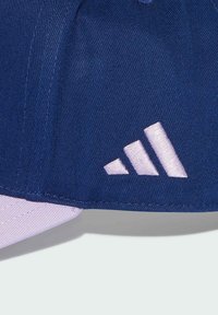 Gorra azul con tela texturizada, con un revestimiento inferior blanco y un logo de tres rayas bordado en rosa claro en el lateral.