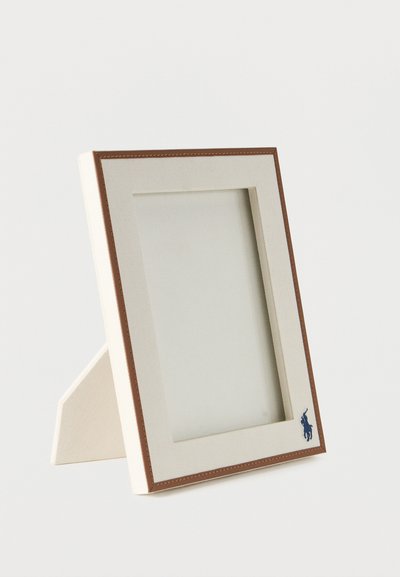 Ορθογώνιο μπεζ κάδρο φωτογραφίας με καφέ άκρες και λογότυπο μπλε παίκτη πόλο στο κάτω δεξιά μέρος, τοποθετημένο πάνω σε λευκή επιφάνεια.