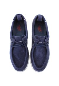 Námořnické modré semišové mokasíny s bílými gumovými podrážkami, kulatou špičkou, šněrovacím designem a decentním brandingem na straně.