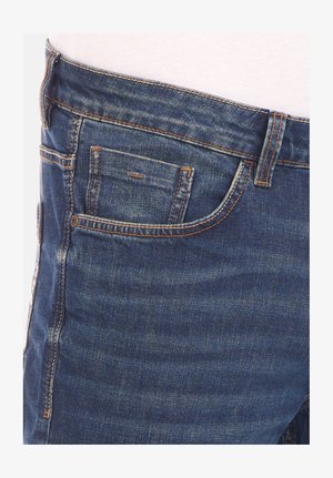 Dark blue denim jeans with a faded finish, featuring orange stitching, multiple pockets, and a classic 5-pocket design.