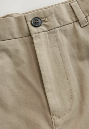 Beige Baumwollhosen mit einer vorderen Knopfverschluss, flachem Bund und feiner Textur, mit Nahtdetails entlang der Nähte.