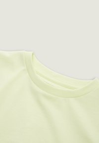 Limegrøn bomulds T-shirt med rund halsudskæring og korte ærmer, der udviser en glat tekstur og minimalistisk design.