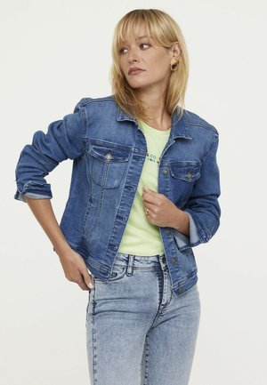 Denim jacket in medium blue with long sleeves, button closure, and two chest pockets; layered over a light green t-shirt.