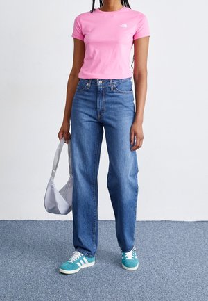 Vaaleanpunainen lyhythihainen t-paita, korkeavyötäröiset siniset farkut, petroolinväriset lenkkarit valkoisin raidoin ja vaaleanharmaa laukku. Minimalistinen muotoilu.