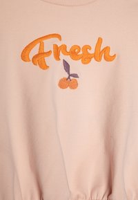 Rosa bomull sweatshirt med "Fresh" i oransje broderi og et kirsebærmotiv. Stoffet har en myk tekstur og en elastisk midje.