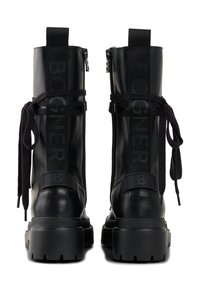 Czarne skórzane buty wojskowe z masywną podeszwą, zamkiem błyskawicznym, ozdobne sznurowania i wyraziste logo z boku. Teksturowany i solidny design.