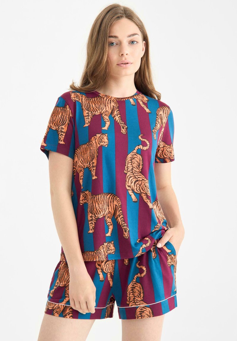Zestaw bluzki z krótkim rękawem i szortów w kolorze niebieskim i bordowym z nadrukiem pomarańczowych tygrysów. Gładki materiał z luźnym krojem i kieszeniami.