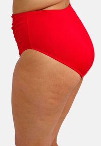 Braguita de bikini roja de talle alto confeccionada en tela suave, con detalles fruncidos a los lados y diseño de cobertura completa.