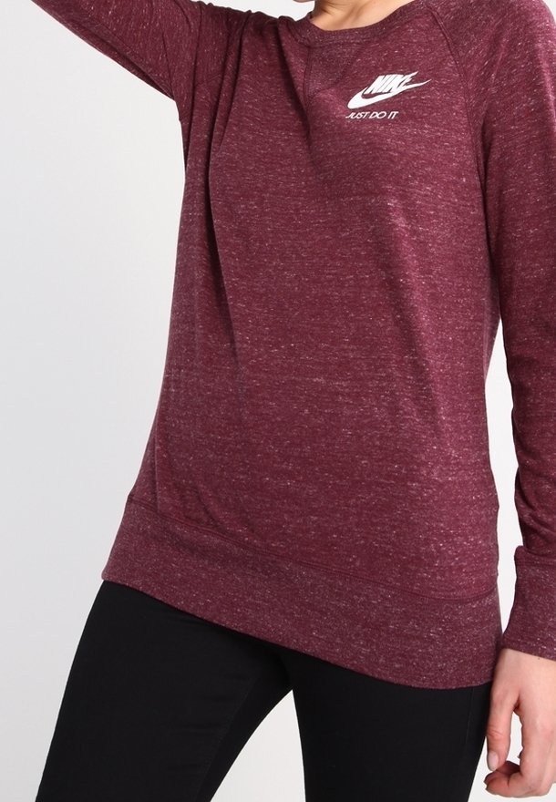 Burgundské dlouhé rukávy tričko s raglánovými rukávy, vyrobené z texturované tkaniny. Obsahuje bílé logo Nike na hrudi.