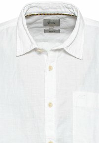 Hvid linned-blanding skjorte med knapper og krave, med en laplomme og kontrastgule sting inde i kraven.