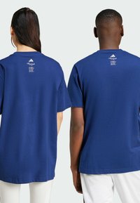 T-shirt in cotone blu navale a maniche corte, con un piccolo logo e testo sul retro. Design classico con collo a girocollo.