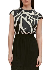 Haut à manches courtes noir et blanc avec motif abstrait et encolure froncée, associé à une taille noire unie. Texture de tissu lisse.