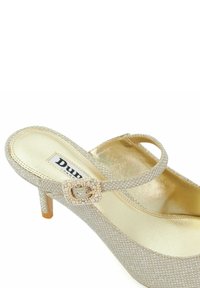 Sandale à talons hauts dorée avec un dessus texturé, une fine lanière de cheville et une boucle décorative ornée de petites perles. Semelle intérieure douce et brillante.