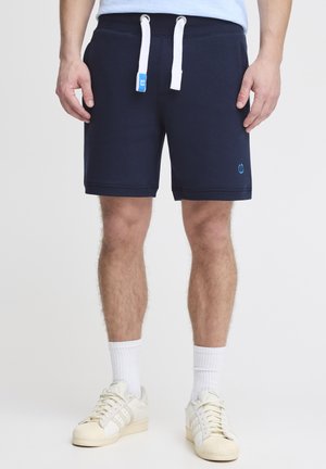 Navyblauwe katoenen jersey shorts met witte drawstrings, zijzakken en een klein blauw logo op de zoom. Gladde textuur, knielange ontwerp.
